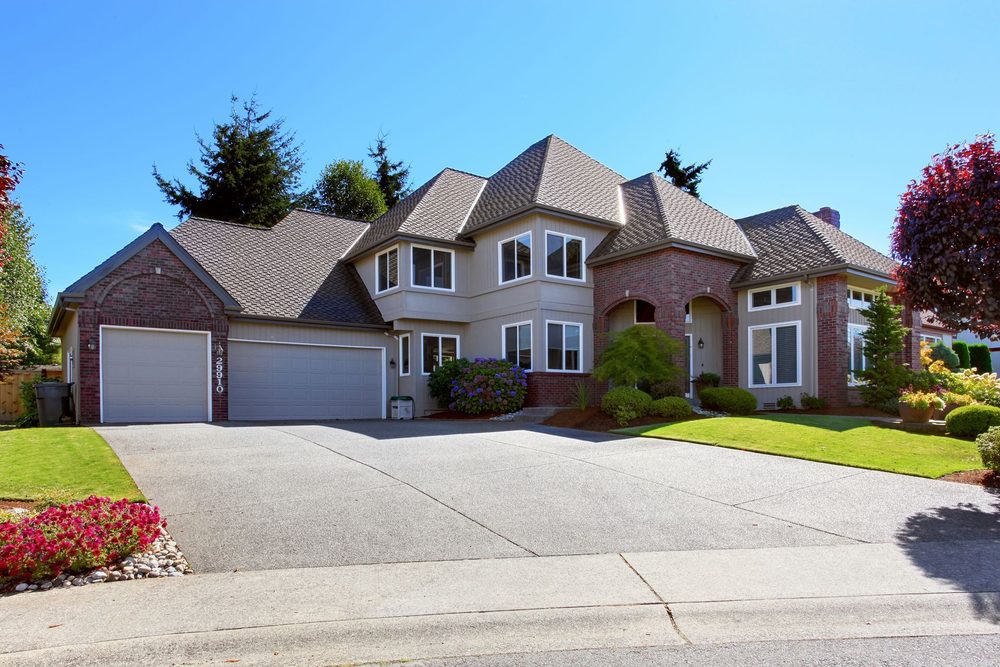 Wide new concrete driveway in front of a two-story home