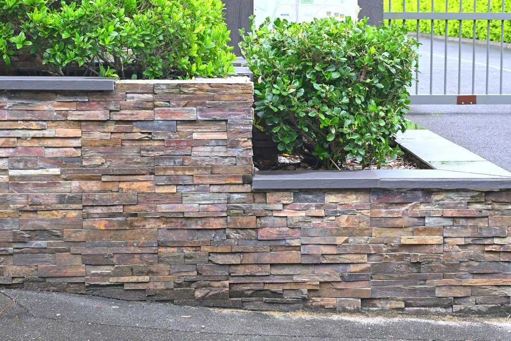 Stone-faced retaining wall with landscaping