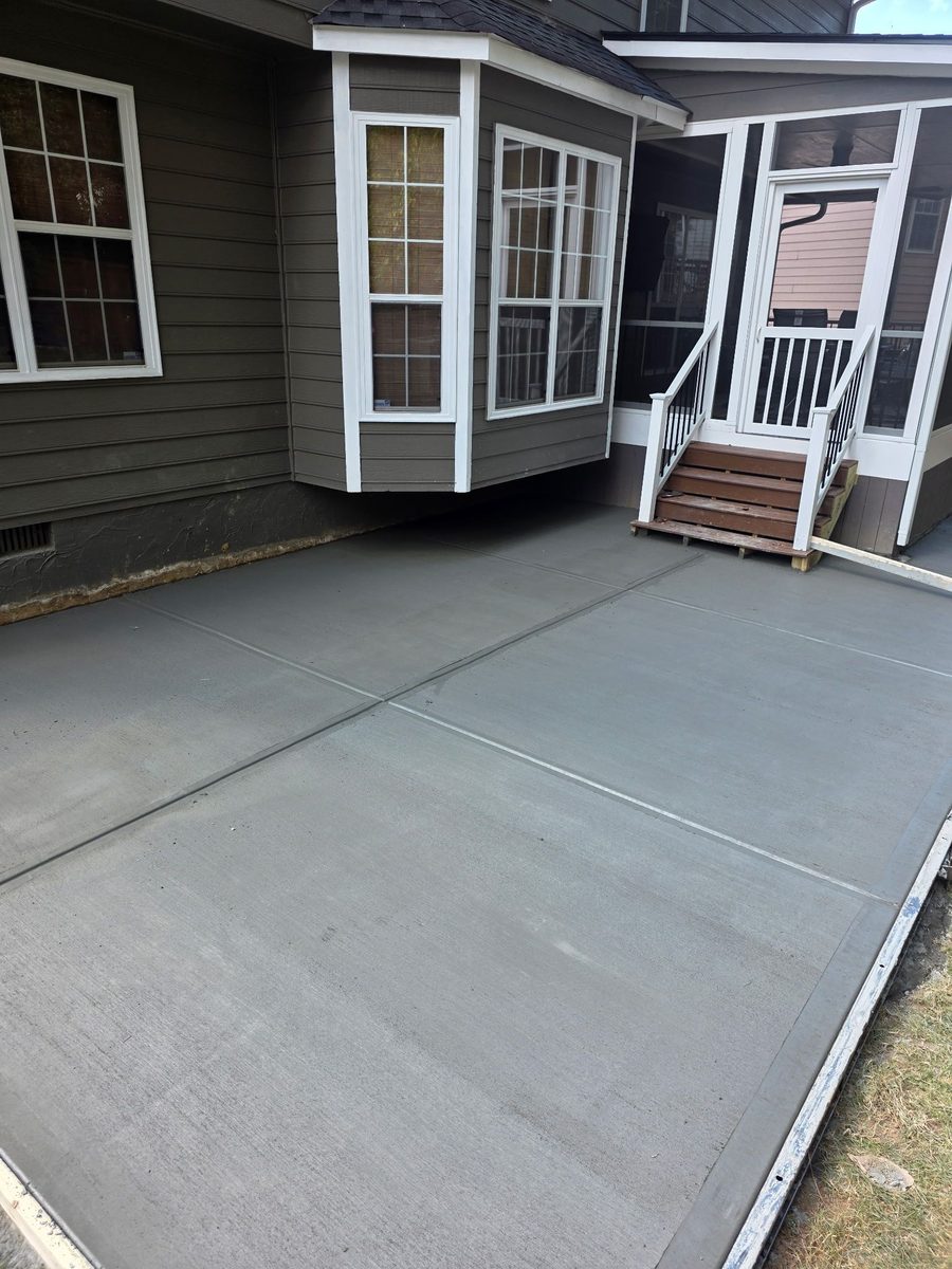 New patio slab poured against a home's back porch